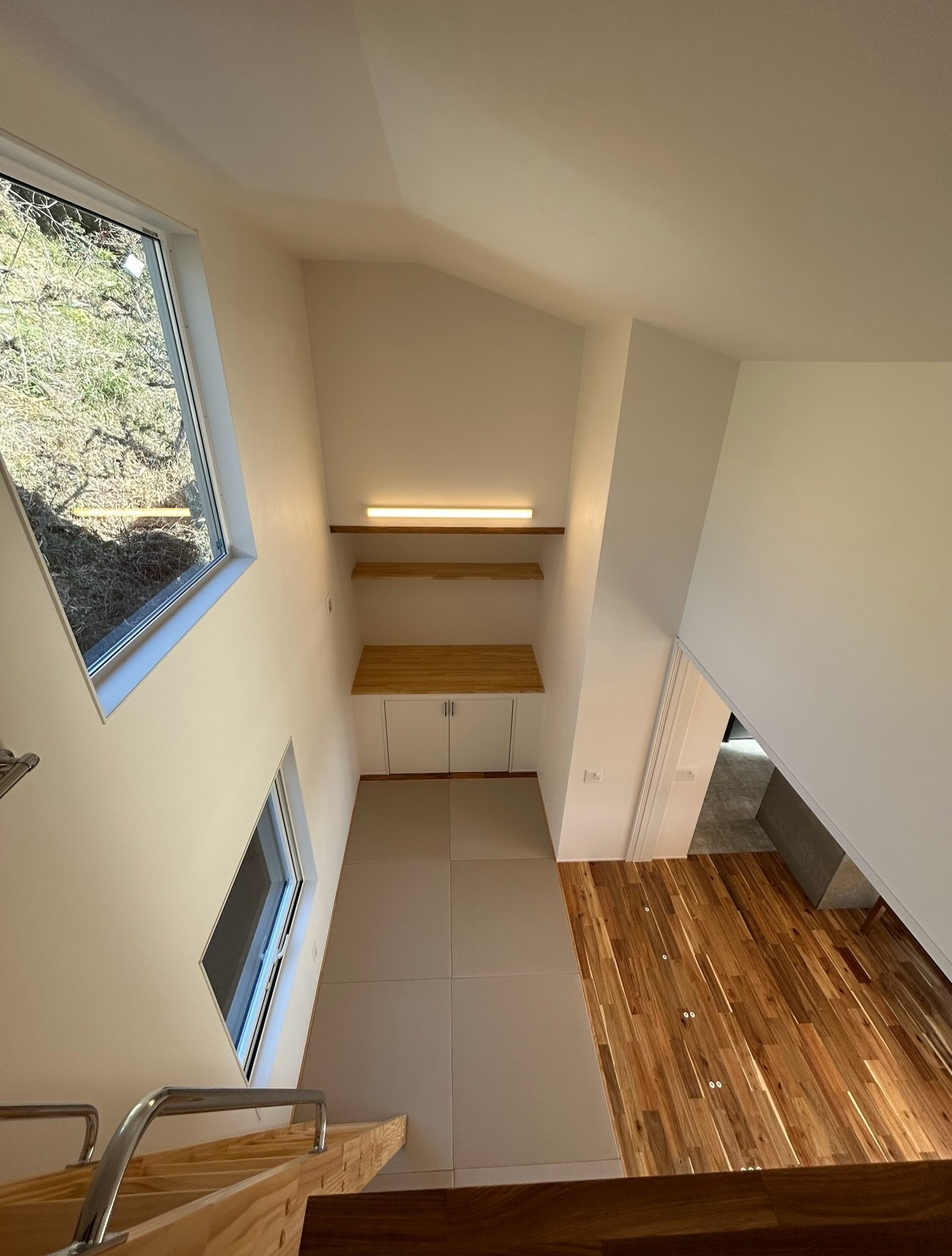 吹き抜けがもたらす開放感と、造作棚の温かい光に包まれる家🏠